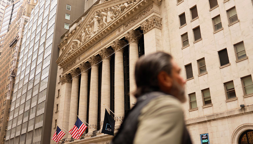 People walk past the New York Stock Exchange during morning trading in New York City.